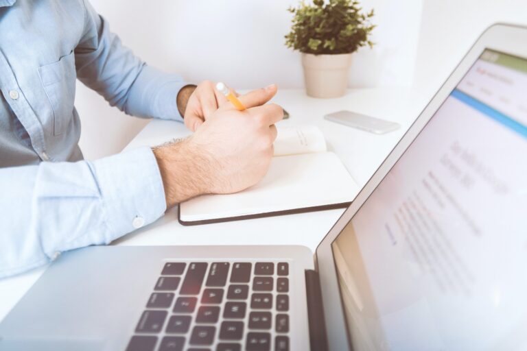 Man taking notes and on laptop